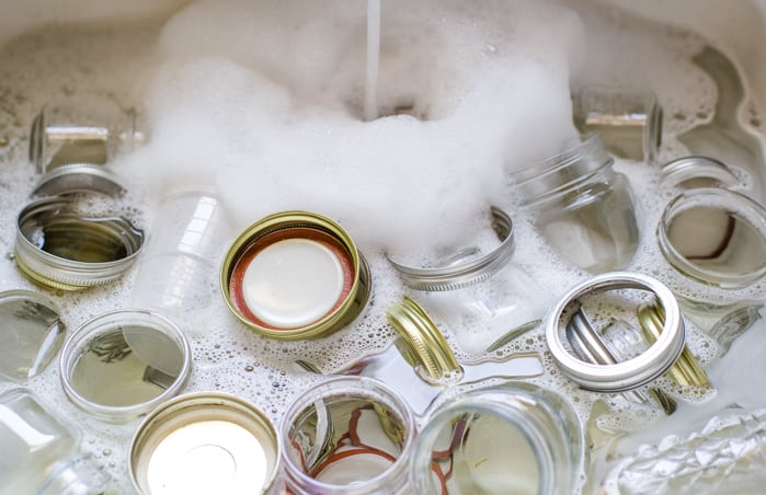 sink with jelly jars in soapy water to clean