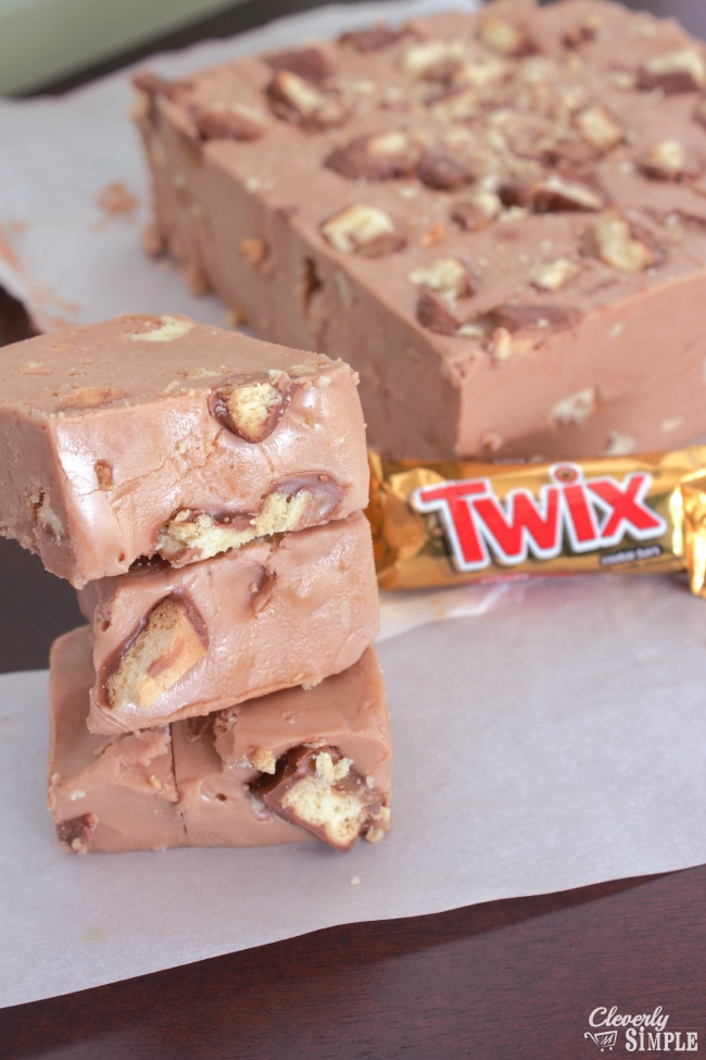 Fudge made with Twix candy cut into slices and on parchment paper