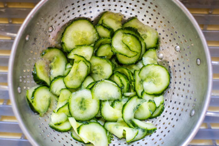 sliced cucumbers in colander