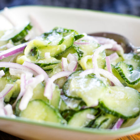 bowl full of german cucumber salad with spoon