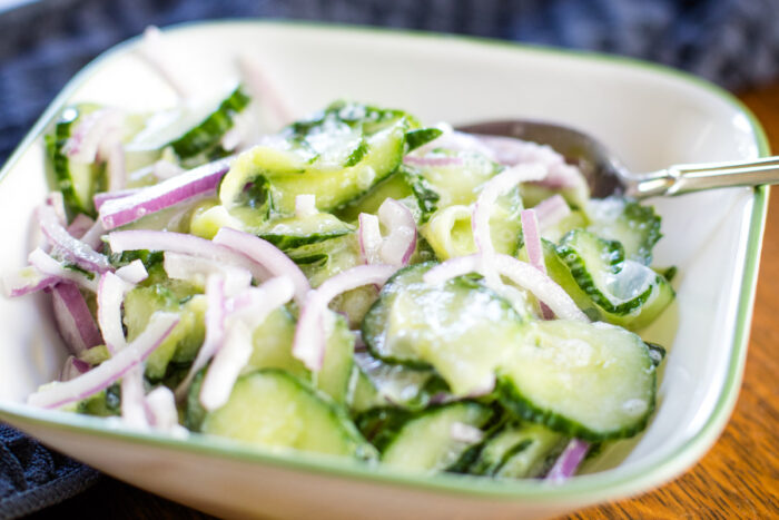 bowl full of german cucumber salad with spoon