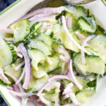German cucumber salad in bowl with spoon