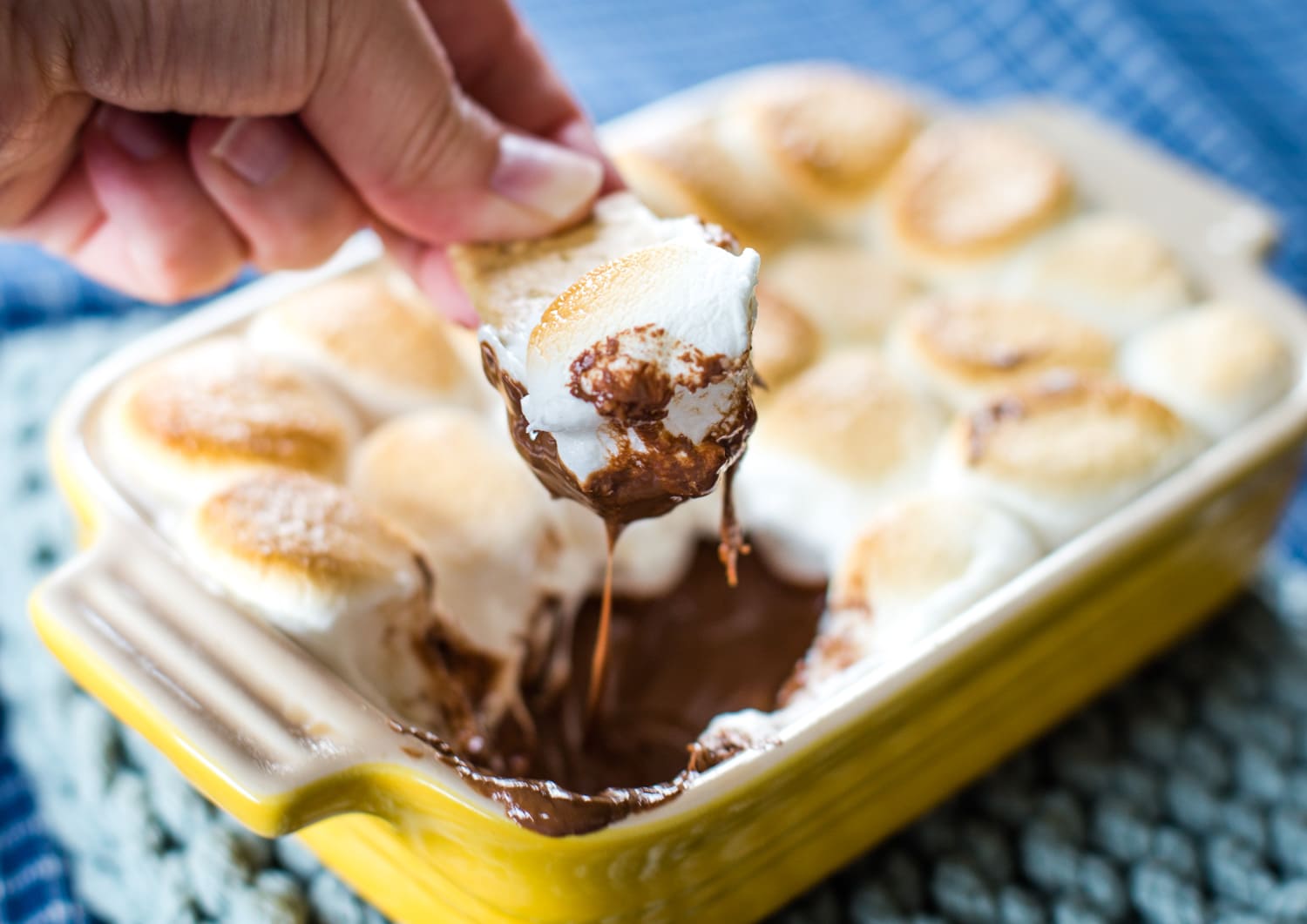 dipping marshamllow and melted chocoalte out of dip with graham cracker