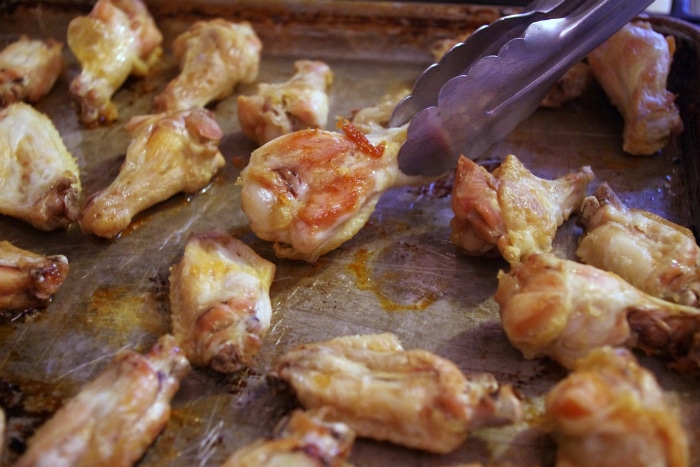 flipping crispy bbq wings on baking pan