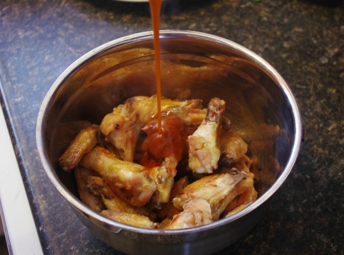 bbq wings in oven with poured sauce