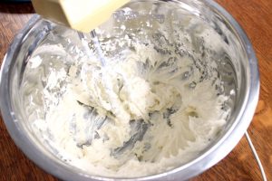 whipping together cream cheese, sugar and cool whip in bowl
