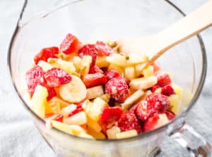 bowl of frozen strawberries, bananas, walnuts and pineapple for frozen fruit salad