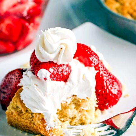 strawberry shortcake with whipped cream and strawberries on plate
