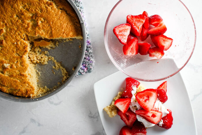 shortcake on plate with bowl of strawberries and shortcake in baking dish