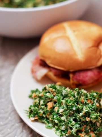 kale salad recipe made on plate with ham sandwich
