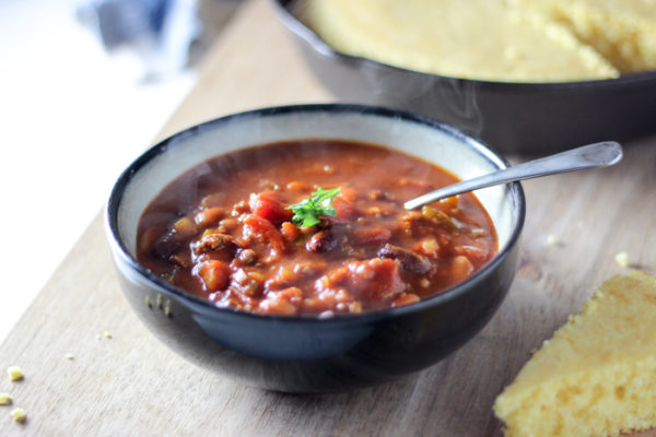 chili in bowl with spoon with cornbread