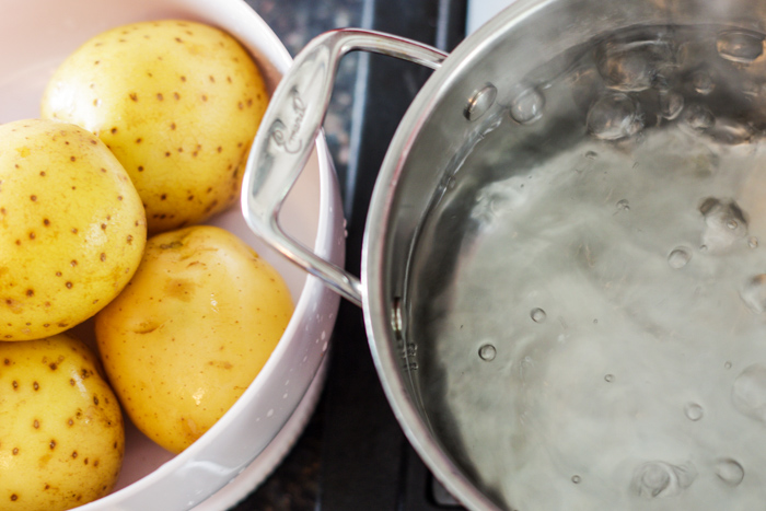 boiling water and raw potatoes in dish
