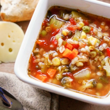 bowl of barley soup in bowl with side of cheese and bread