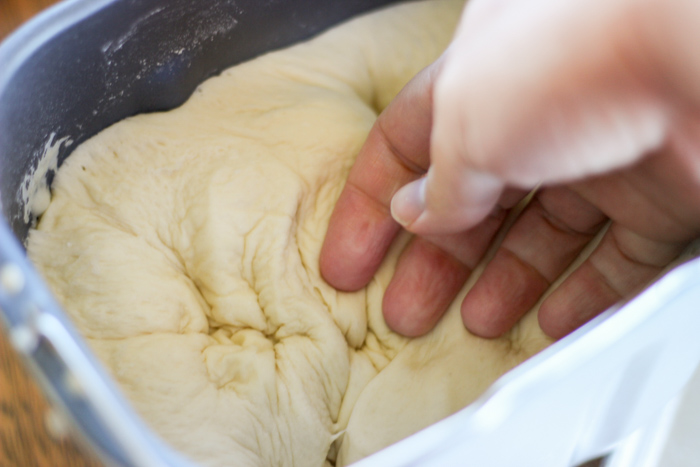 punching down risen dough for dinner rolls