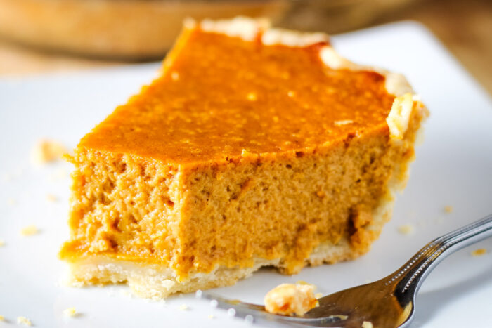 close up of pumpkin pie with bite taken out of it