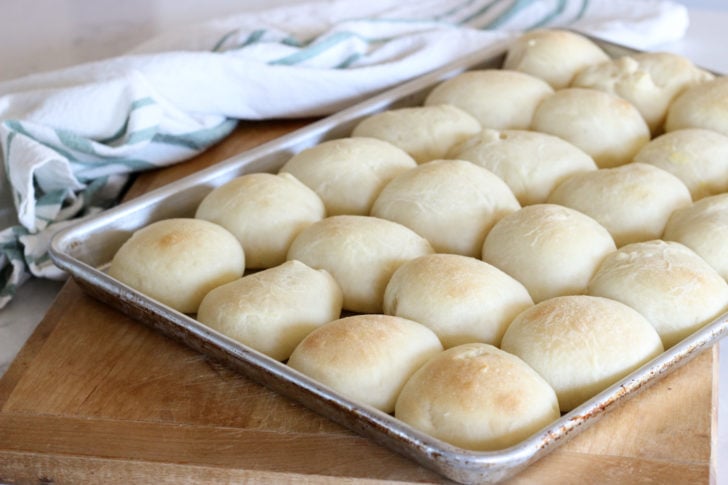 fresh baked dinner rolls on baking sheet