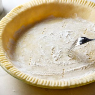 sticking a fork into the pie crust dough