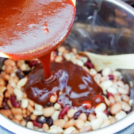homemade bbq sauce being poured over beans