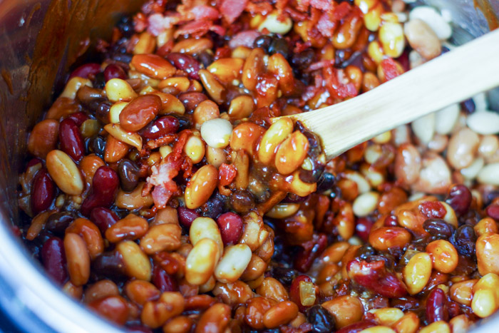 stirring slow cooker beans with bacon