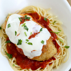 baked chicken Parmesan in bowl with angel hair pasta