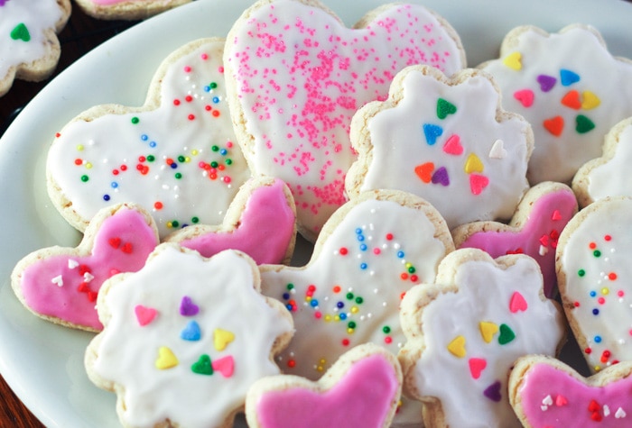 plate of gluten free sugar cookies with icing and sprinkles