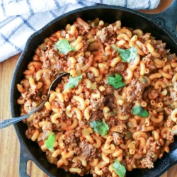 cast iron skillet with macaroni and beef on table
