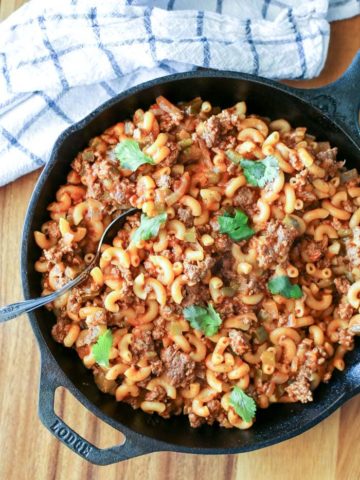 cast iron skillet with macaroni and beef on table