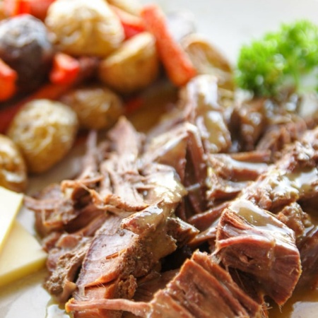 Plate of venison steak with a side of roasted potatoes.