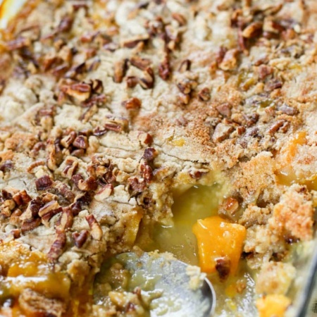 peach dump cake with spoon resting in dish