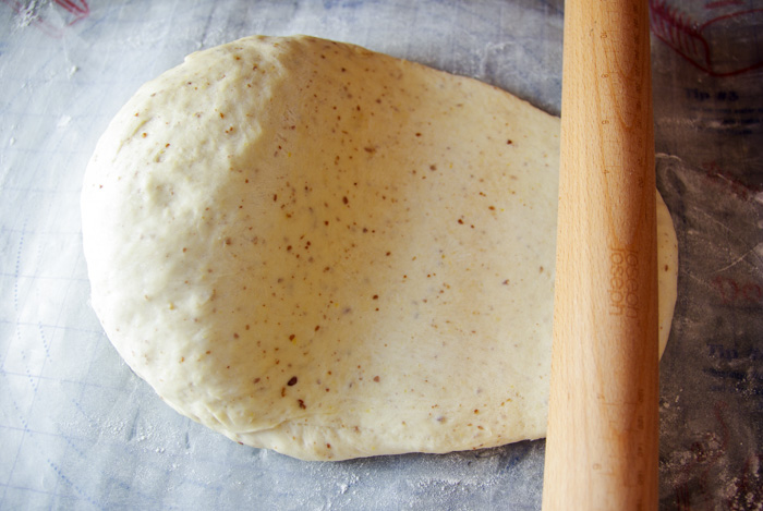 rolling out vegan cinnamon roll dough