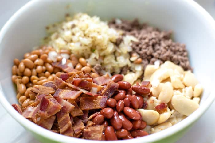 bacon, ground beef, onions and beans in bowl
