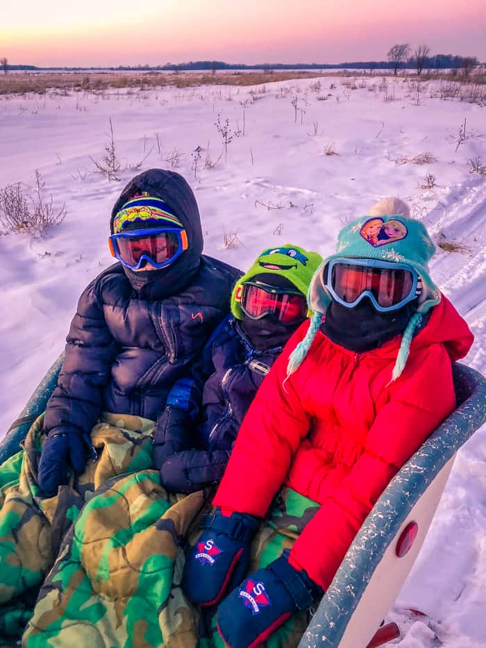 kids on snowmobile sleigh