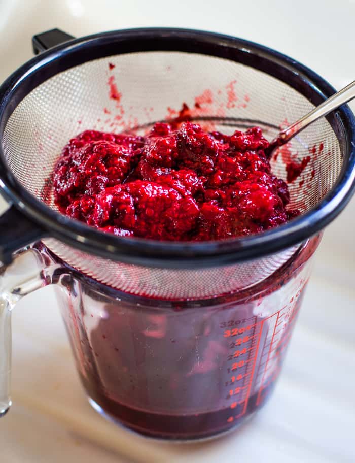 frozen raspberries draining to make raspberry sauce