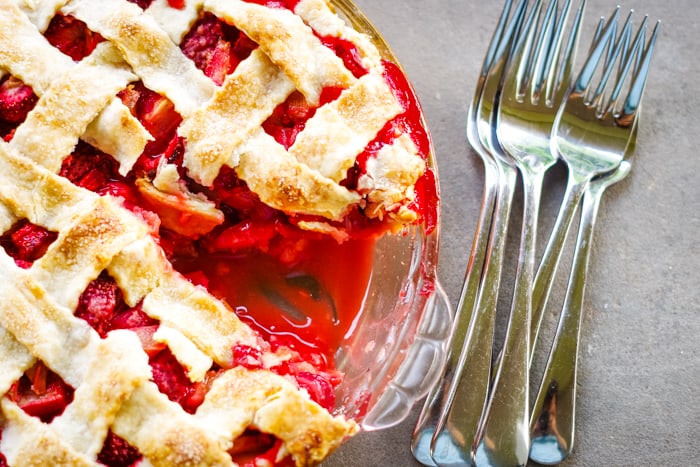strawberry rhubarb pie with cut out and forks