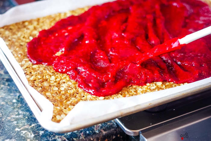spreading layer of cranberry on oatmeal base