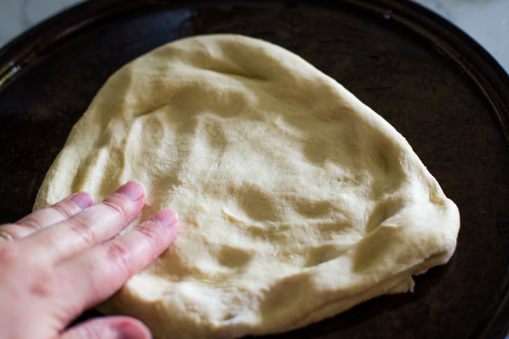 spread pizza dough by hand