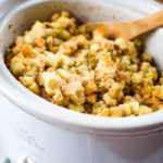 slow cooker stuffing in crockpot with wooden spoon