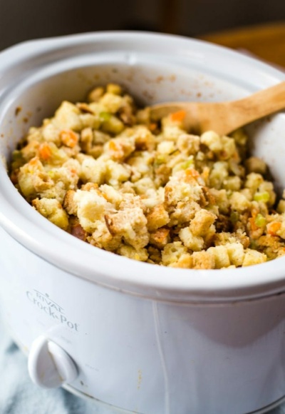 slow cooker stuffing in crockpot with wooden spoon