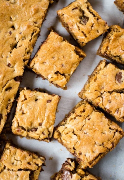 blonde brownie cut in squares on parchment paper