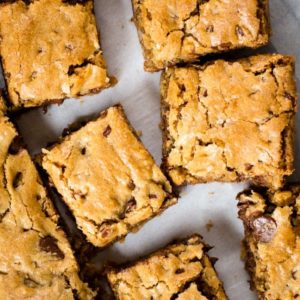 blonde brownie with nuts on parchment paper