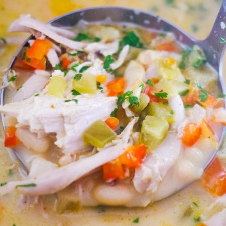 ladel of white bean soup dipping out of stockpot
