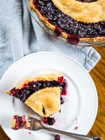 blueberry pie slice on plate with fork