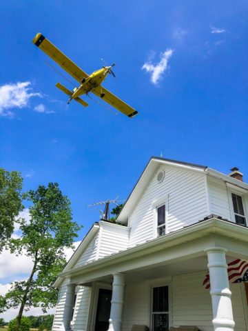 crop duster over house