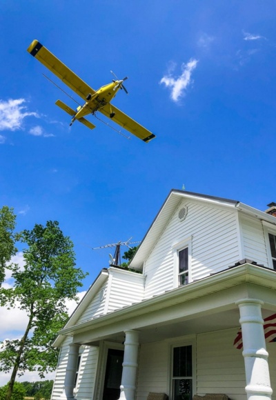crop duster over house