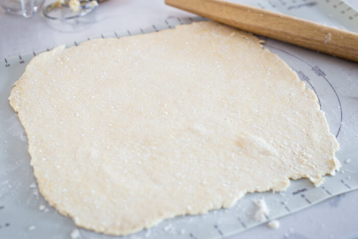 rolled out dough on pastry mat with rolling pin