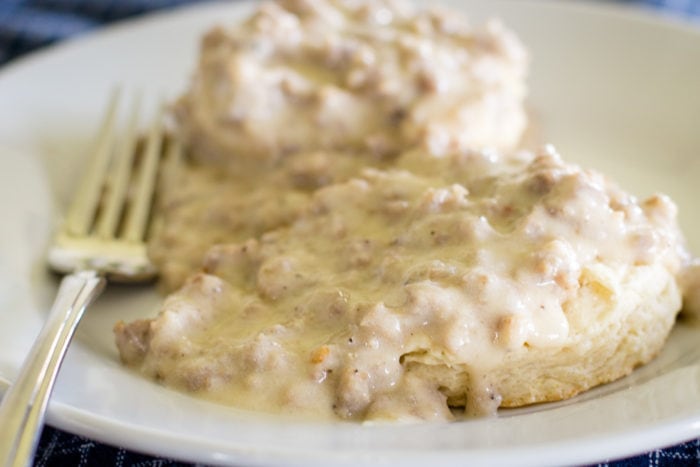 plate of sausage and gravy over biscuits