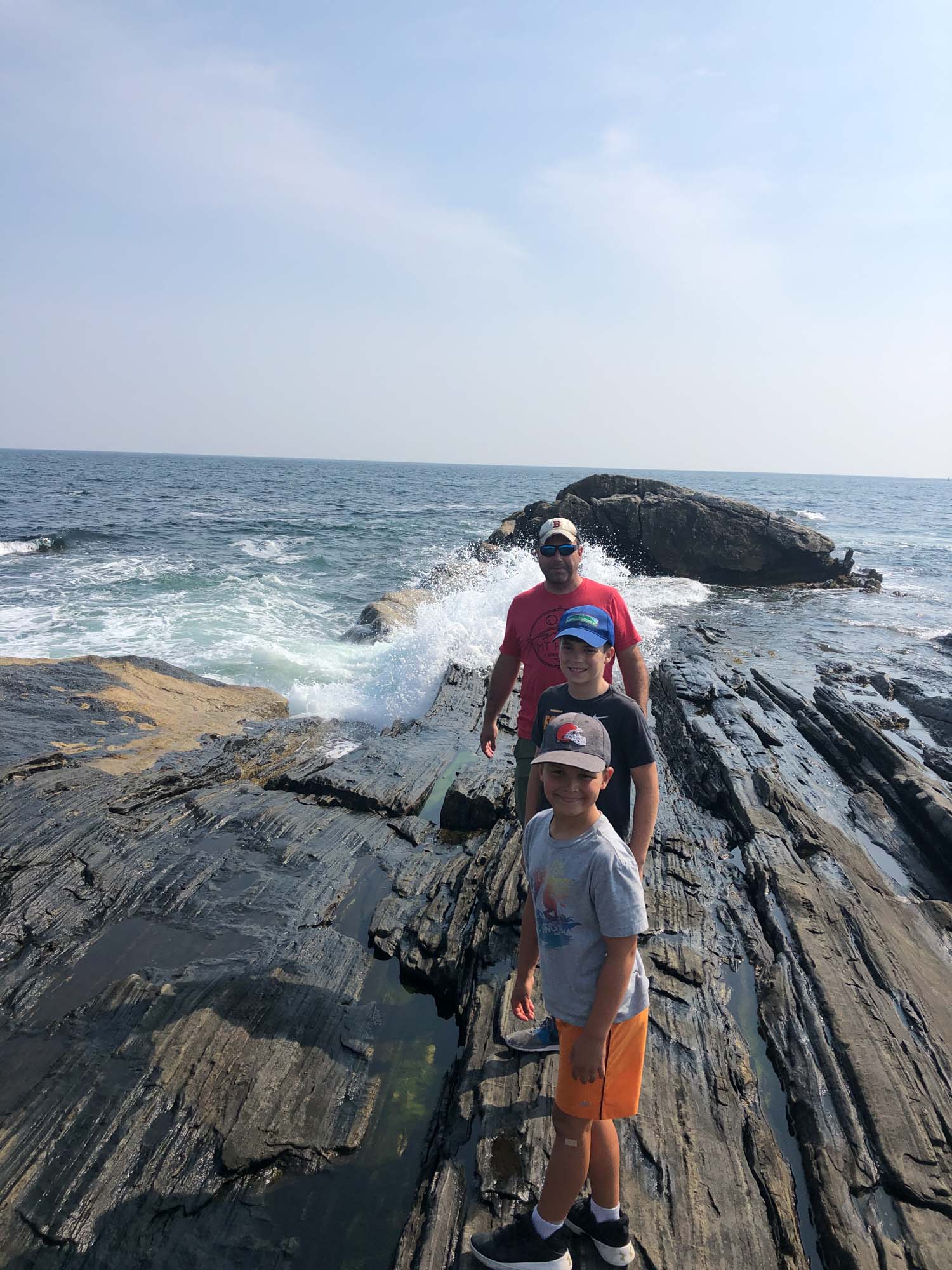 family at rocks in front of ocean