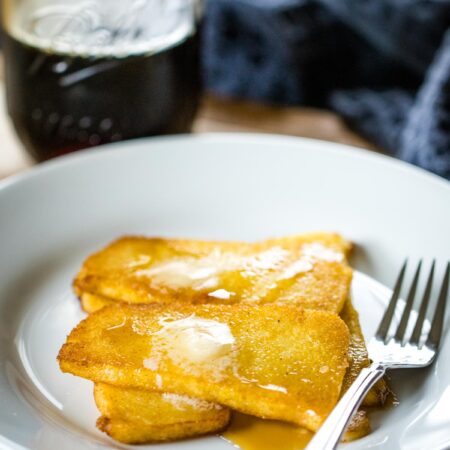 fried mush on plate with maple syrup and butter