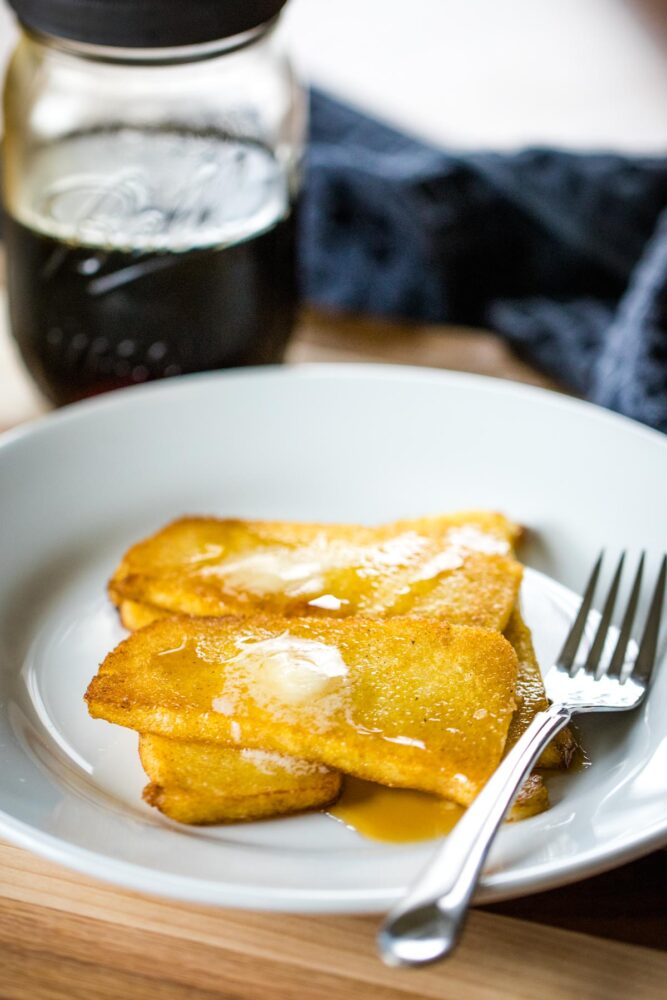 fried mush on plate with maple syrup and butter