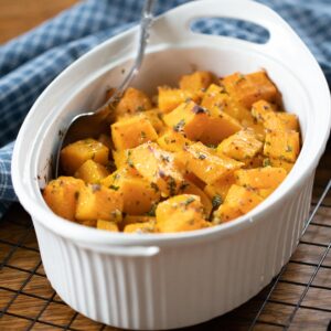 roasted butternut squash in a baking dish with spoon